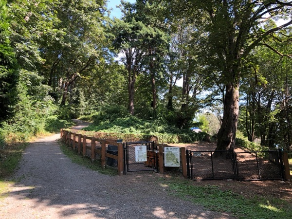 Kinnear Park entrance and off-leash area gate, with an encampment tent visible in the background